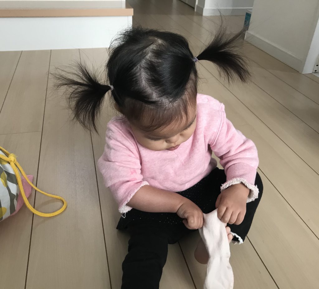 1歳の娘が自分で靴下をはいているところ